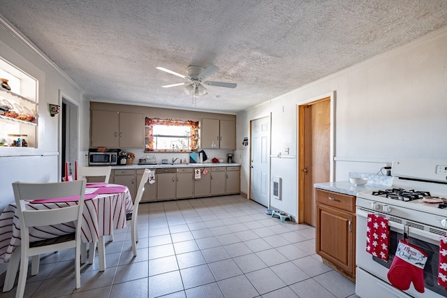 kitchen with crown molding, ceiling fan, a textured ceiling, gas range gas stove, and light tile patterned flooring