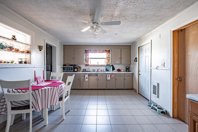 kitchen with ceiling fan, crown molding, a textured ceiling, decorative backsplash, and light tile patterned floors