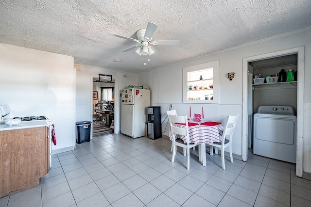 dining space with ceiling fan, washer / dryer, ornamental molding, and a textured ceiling