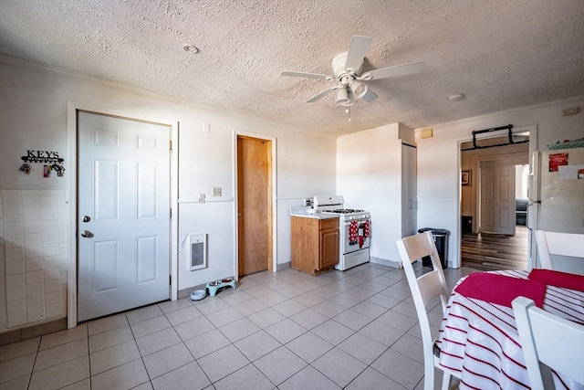 kitchen featuring white appliances, a textured ceiling, light tile patterned floors, and heating unit