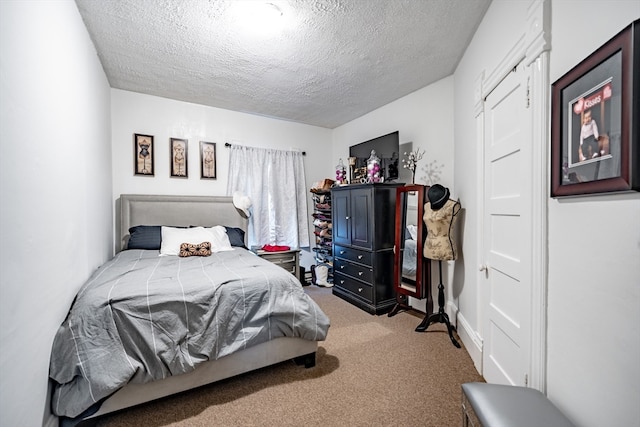 bedroom with a textured ceiling and light carpet