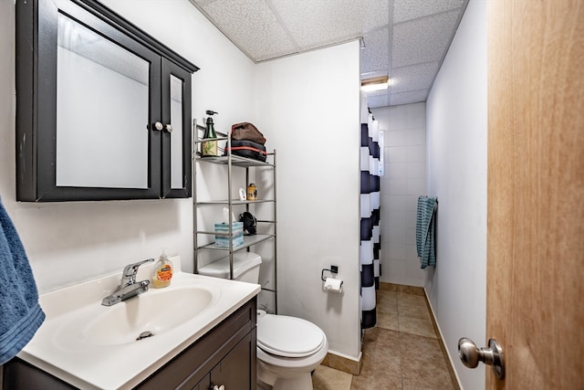 bathroom with vanity, a drop ceiling, tile patterned floors, a shower with curtain, and toilet