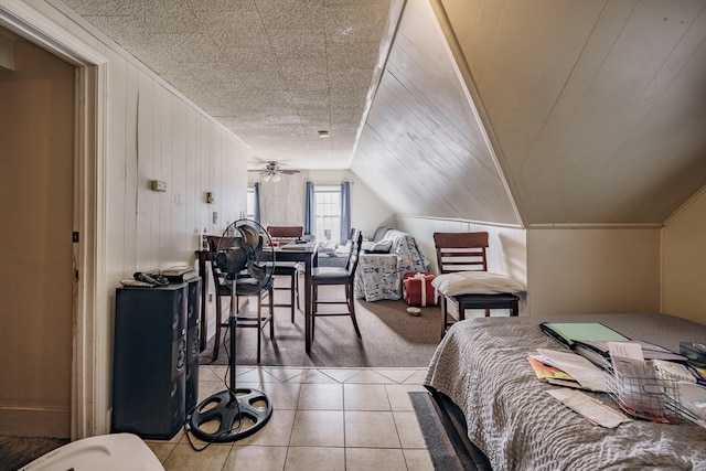 bedroom with tile patterned floors, wood walls, and vaulted ceiling