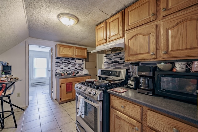 kitchen with decorative backsplash, stainless steel range with gas cooktop, light tile patterned floors, and a textured ceiling