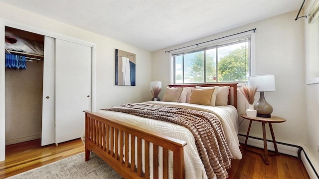 41 Lee Rd, Needham, MA 02494 - bedroom featuring wood finished floors, a closet, baseboard heating, and a baseboard radiator