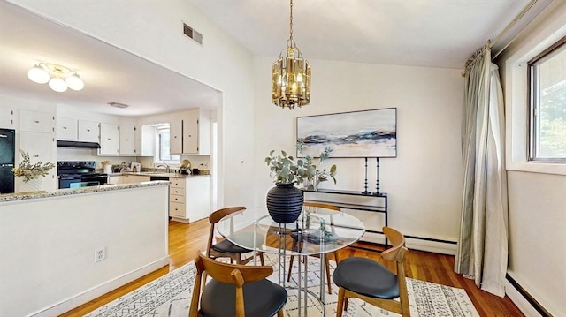 41 Lee Rd, Needham, MA 02494 - dining space with light wood finished floors, a chandelier, baseboards, and baseboard heating