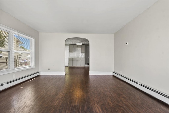 27 Whittier St, Fall River, MA 02724 - empty room with baseboard heating, arched walkways, and wood finished floors