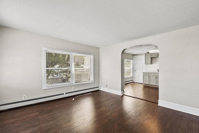 27 Whittier St, Fall River, MA 02724 - spare room with arched walkways, wood finished floors, and a baseboard heating unit