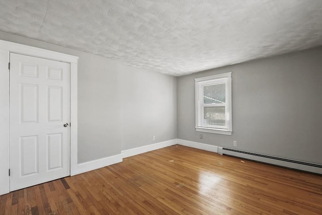 27 Whittier St, Fall River, MA 02724 - unfurnished room with wood-type flooring, a baseboard heating unit, and a textured ceiling