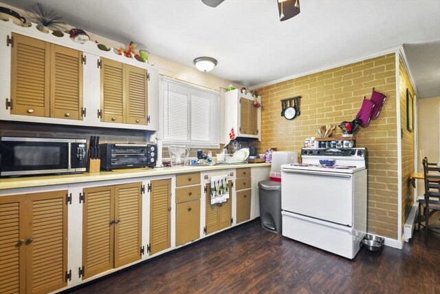 27 Whittier St, Fall River, MA 02724 - kitchen featuring white electric range, stainless steel microwave, dark wood-type flooring, light countertops, and brick wall