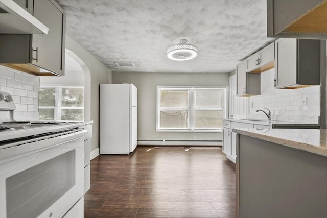27 Whittier St, Fall River, MA 02724 - kitchen featuring white appliances, under cabinet range hood, dark wood-type flooring, light stone countertops, and baseboard heating