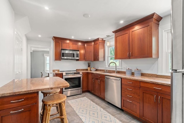 11 Netta Rd, Dedham, MA 02026 - kitchen featuring appliances with stainless steel finishes, a sink, recessed lighting, light stone countertops, and brown cabinetry