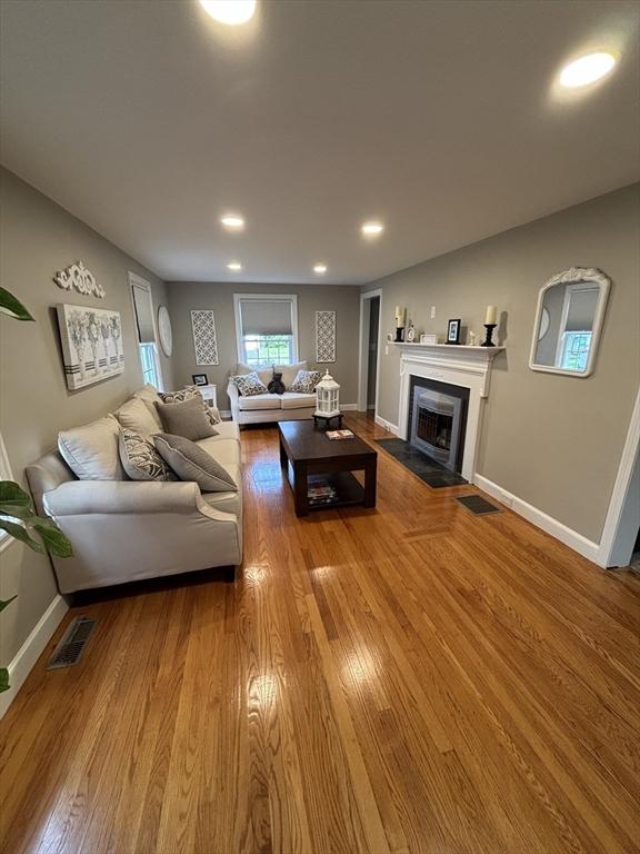 259 Gillette Ave, Springfield, MA 01118 - living area with wood finished floors, a fireplace with flush hearth, baseboards, and recessed lighting