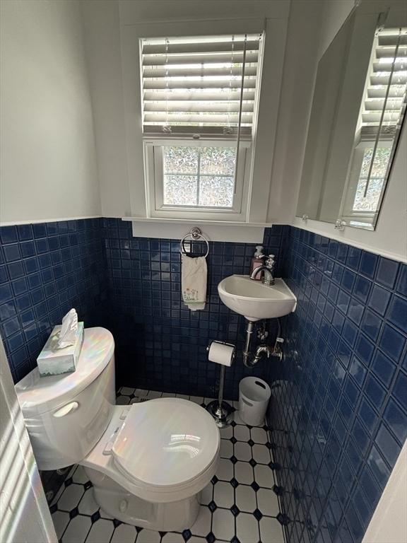 259 Gillette Ave, Springfield, MA 01118 - half bath featuring tile walls, toilet, wainscoting, plenty of natural light, and tile patterned floors