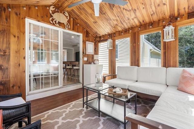 living room featuring wood finished floors, wooden walls, wooden ceiling, a ceiling fan, and vaulted ceiling
