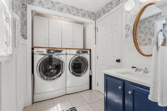 laundry area featuring a sink, light tile patterned floors, washing machine and dryer, and wallpapered walls