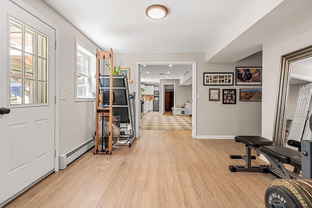 entrance foyer featuring baseboards, a baseboard heating unit, and light wood finished floors