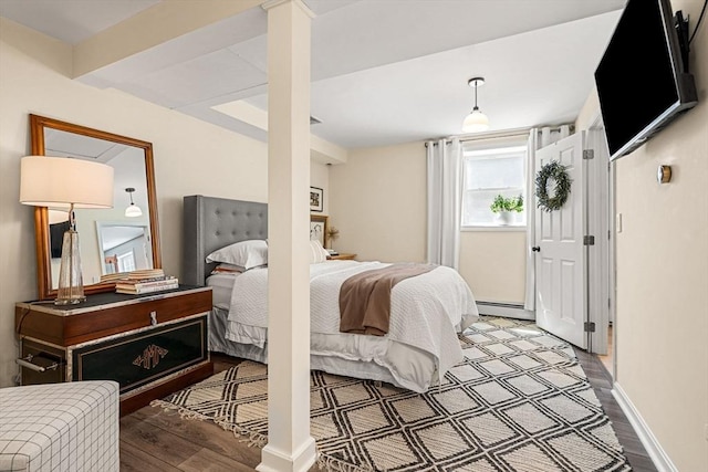 bedroom with baseboards, a baseboard heating unit, and wood finished floors