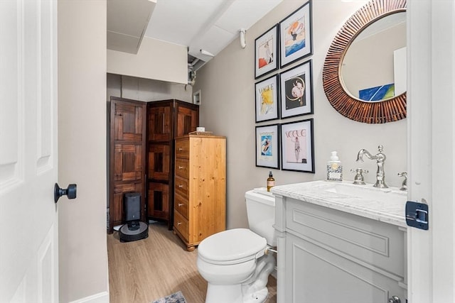 bathroom featuring vanity, wood finished floors, and toilet