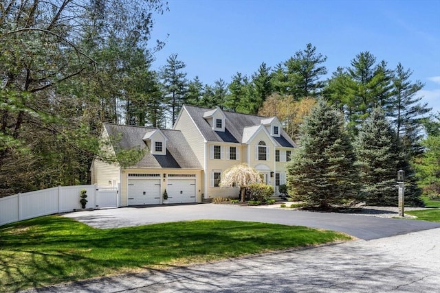 view of front of house with fence, driveway, a gate, and a front lawn