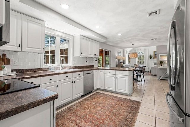 kitchen featuring a sink, plenty of natural light, stainless steel appliances, and a peninsula