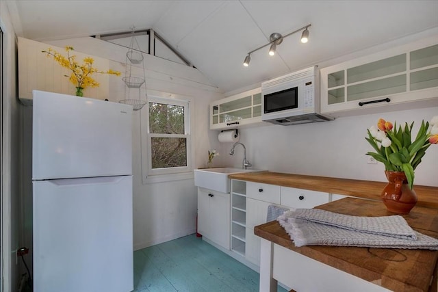 82 Shore Rd Unit 9, Truro, MA 02652 - kitchen featuring white appliances, white cabinets, light wood finished floors, glass insert cabinets, and vaulted ceiling
