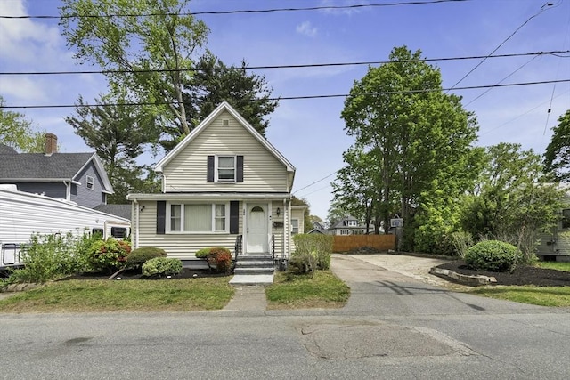 view of front facade with driveway and fence
