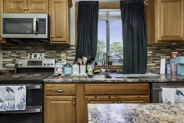 kitchen featuring decorative backsplash, stainless steel appliances, brown cabinets, and a sink