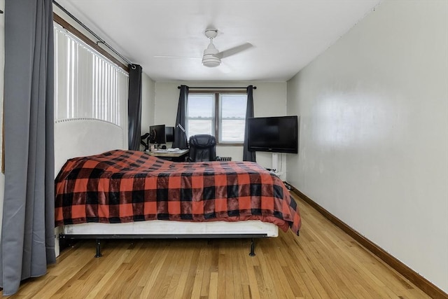 bedroom with baseboards, a ceiling fan, and wood finished floors
