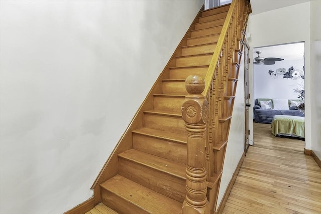 stairway featuring baseboards and hardwood / wood-style floors
