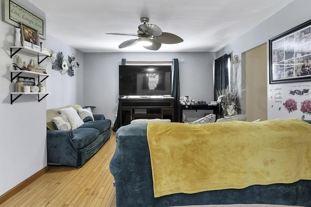 living room featuring a ceiling fan, hardwood / wood-style floors, and baseboards