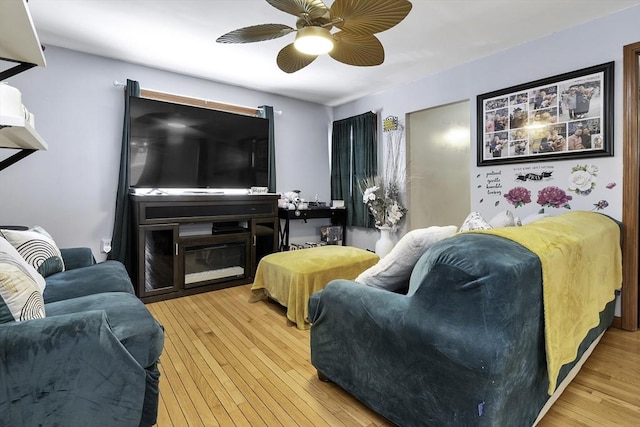 living area with a ceiling fan and hardwood / wood-style flooring