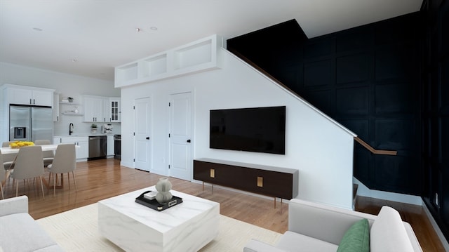 living room featuring sink and light hardwood / wood-style floors