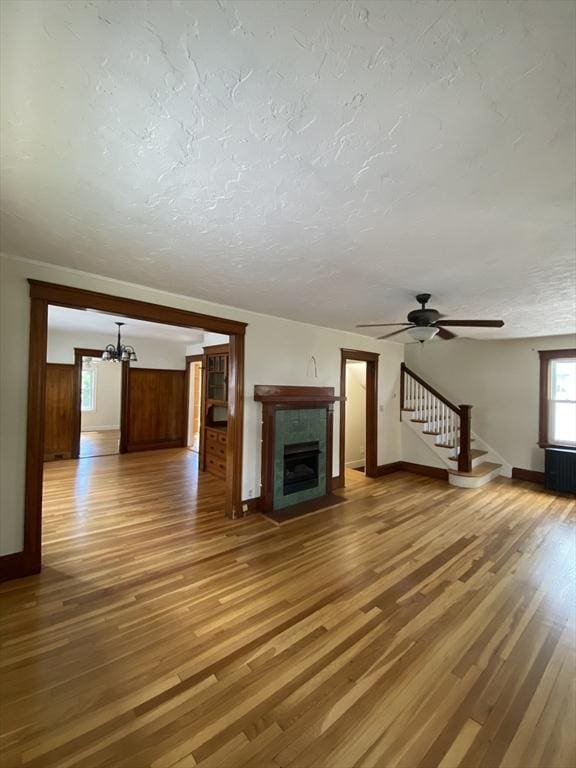 295 Atlantic, Quincy, MA 02171 - unfurnished living room with wood finished floors, stairs, a chandelier, a fireplace, and radiator heating unit