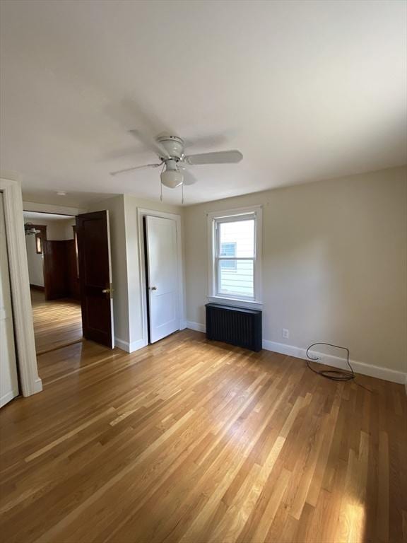 295 Atlantic, Quincy, MA 02171 - unfurnished bedroom with radiator, light wood finished floors, and a ceiling fan