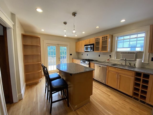 295 Atlantic, Quincy, MA 02171 - kitchen featuring appliances with stainless steel finishes, a kitchen island, light wood-style flooring, glass insert cabinets, and recessed lighting