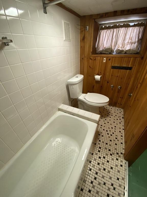 295 Atlantic, Quincy, MA 02171 - full bath with tile patterned floors, a tub, and wooden walls