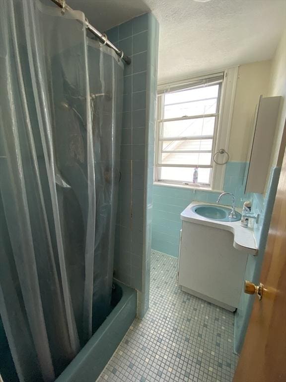 295 Atlantic, Quincy, MA 02171 - full bathroom featuring vanity, tile patterned floors, shower / bath combo, tile walls, and a textured ceiling