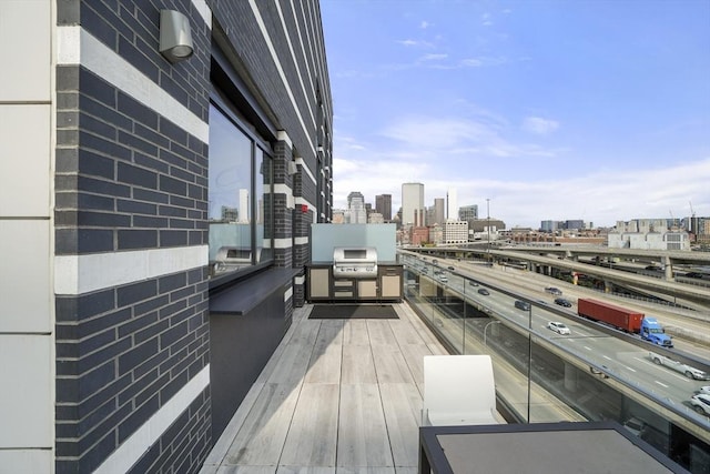 balcony featuring exterior kitchen, a view of city, and a grill