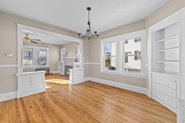 unfurnished dining area with plenty of natural light, radiator heating unit, and light hardwood / wood-style floors