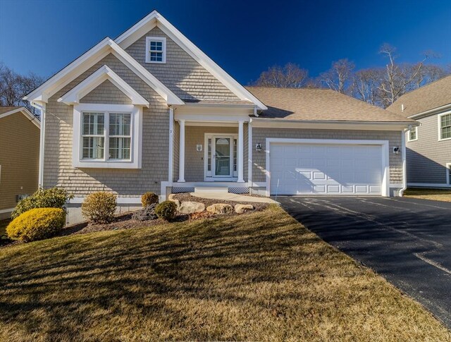 view of front of home with driveway, an attached garage, and a front lawn