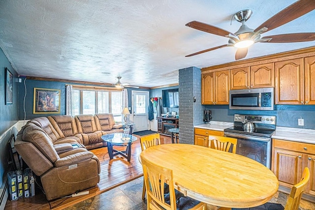 214 Hovenden Ave, Brockton, MA 02302 - kitchen with appliances with stainless steel finishes, a ceiling fan, light countertops, open floor plan, and brown cabinets