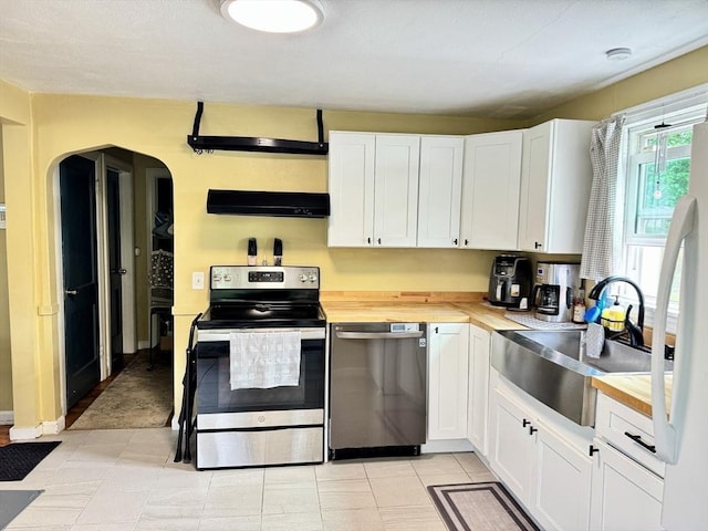 169 Beauchamp Ter, Chicopee, MA 01020 - kitchen featuring appliances with stainless steel finishes, exhaust hood, arched walkways, and white cabinetry