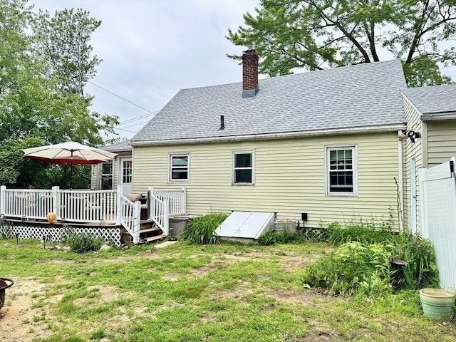 169 Beauchamp Ter, Chicopee, MA 01020 - rear view of property featuring a wooden deck, a chimney, roof with shingles, and a yard