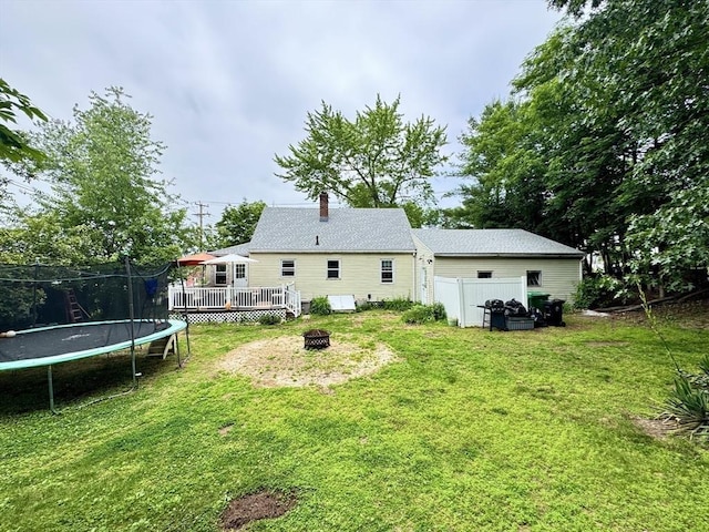 169 Beauchamp Ter, Chicopee, MA 01020 - rear view of house with a fire pit, a deck, a trampoline, and a chimney