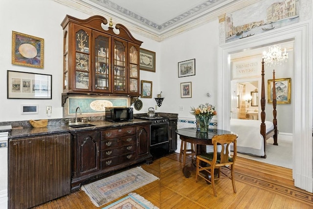 338 Harvard St Unit 1, Cambridge, MA 02139 - bar area with black microwave, range with gas stovetop, ornamental molding, a chandelier, and stainless steel dishwasher