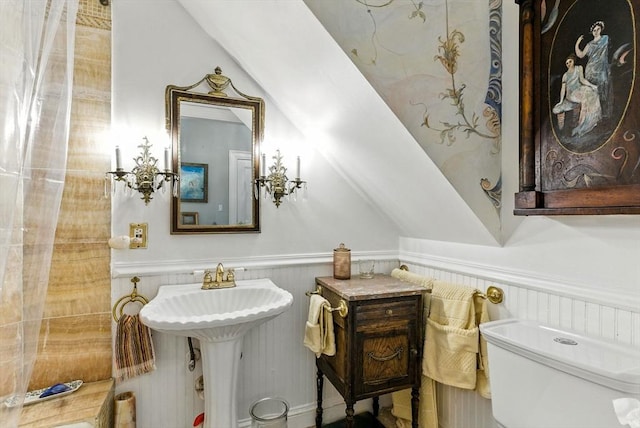 338 Harvard St Unit 1, Cambridge, MA 02139 - bathroom featuring wainscoting and lofted ceiling