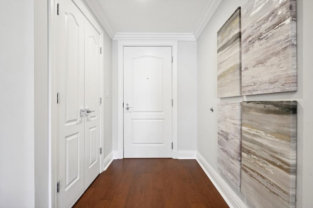 hall with dark wood finished floors, baseboards, and ornamental molding