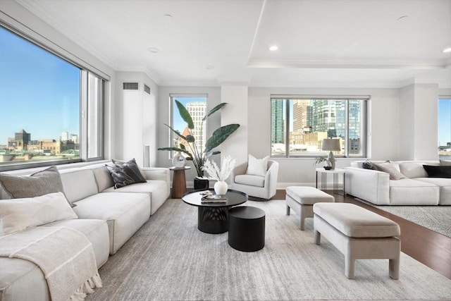 living area with recessed lighting, wood finished floors, visible vents, and ornamental molding