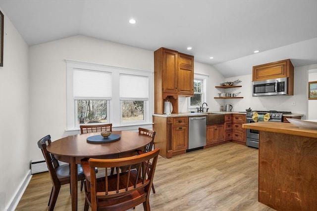 kitchen with brown cabinets, open shelves, appliances with stainless steel finishes, vaulted ceiling, and light wood-type flooring